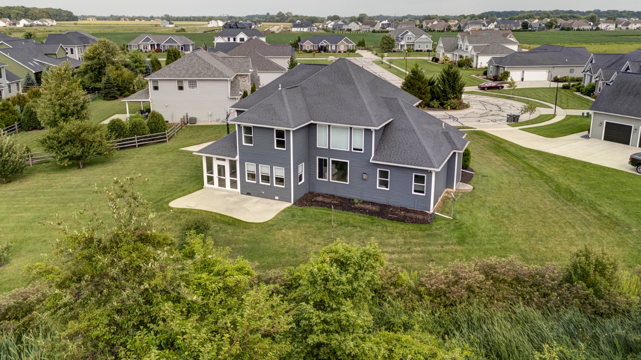 Elevated rear view of the home, lawn, patio and surrounding neighborhood