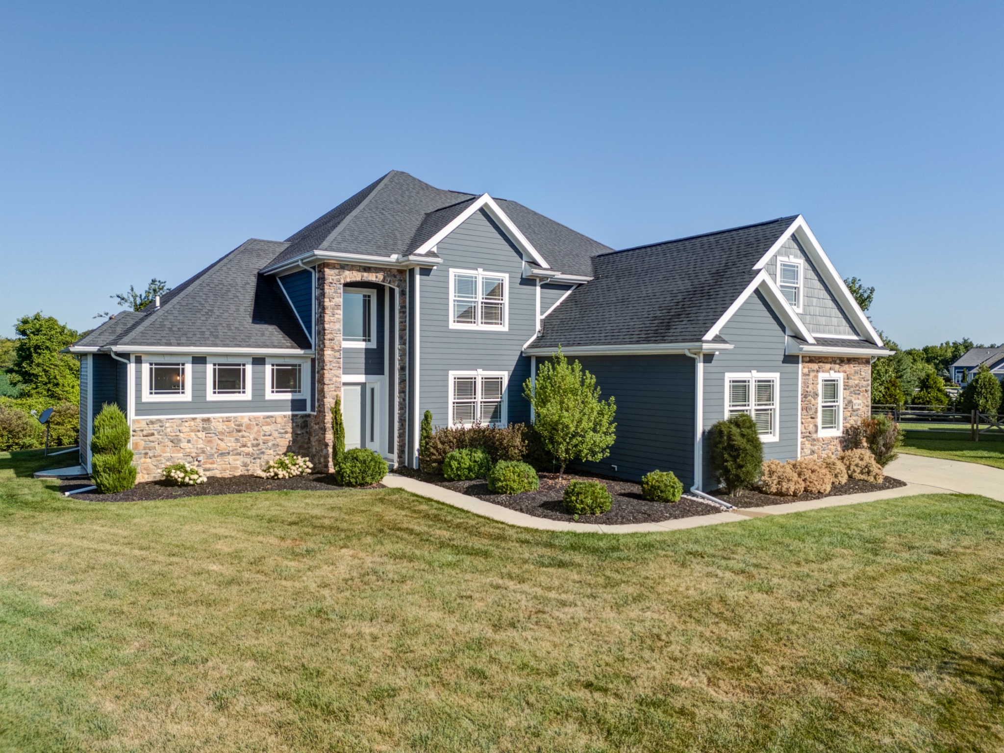 Angled front view highlighting the stone and siding exterior
