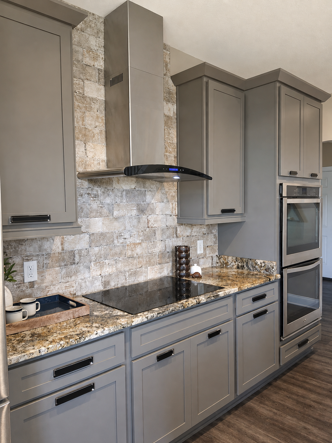Cooktop, statement range hood and stone backsplash